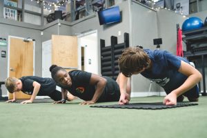 coach at Bent On Better instructing young boy how to properly do a push-up