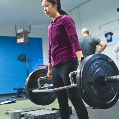 a woman doing a trap bar pull at a gym