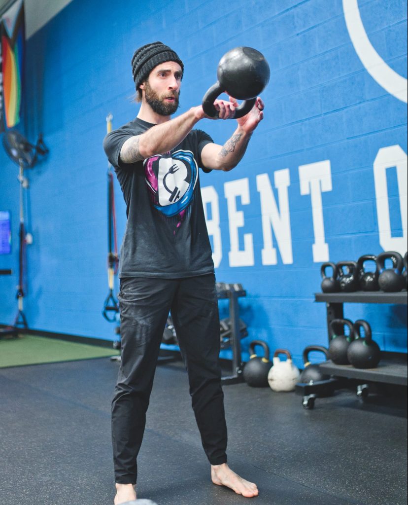a man lifting a kettlebell in a gym