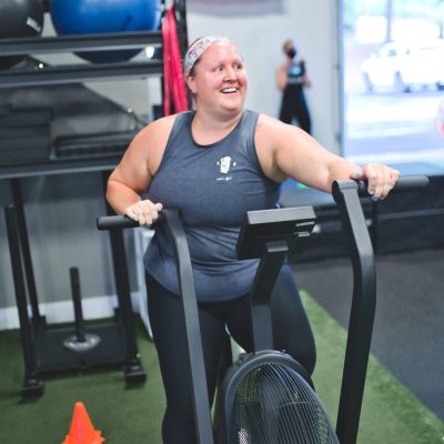 A woman riding an Echo Bike in a gym