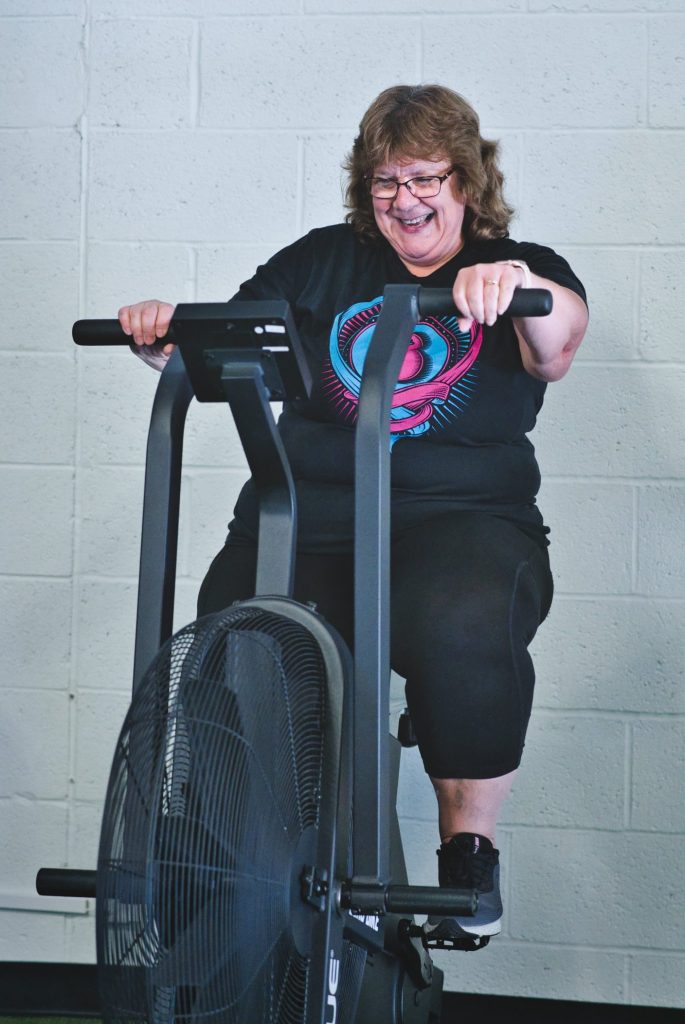 a woman riding a Rogue Echo Bike in a gym