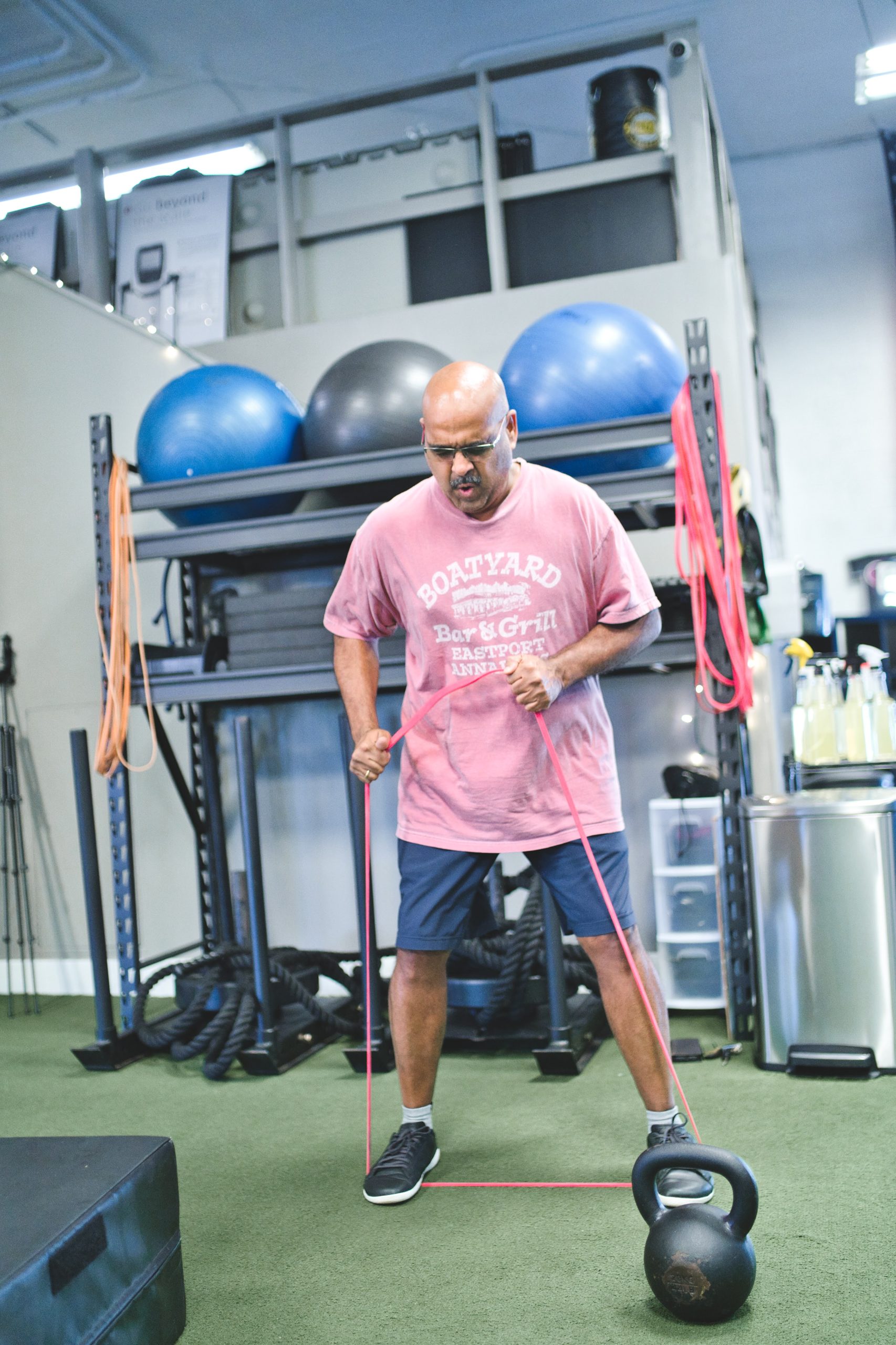 A man working out using resistance bands in a gym.