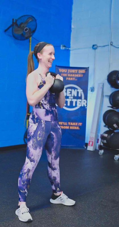 a woman lifting a kettlebell in a gym